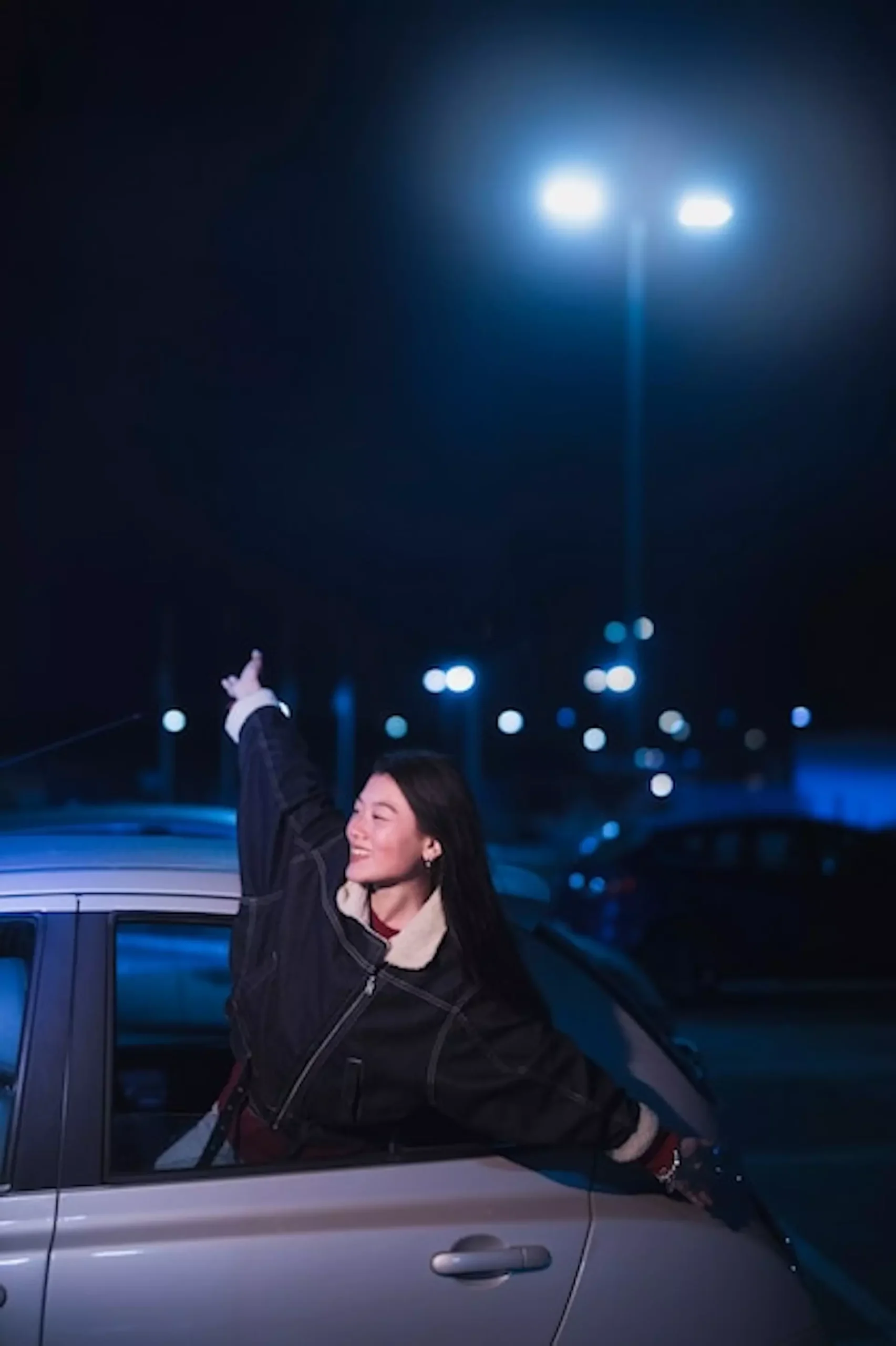 Jeune adulte prenant l'aire en dehors de son taxi la nuit