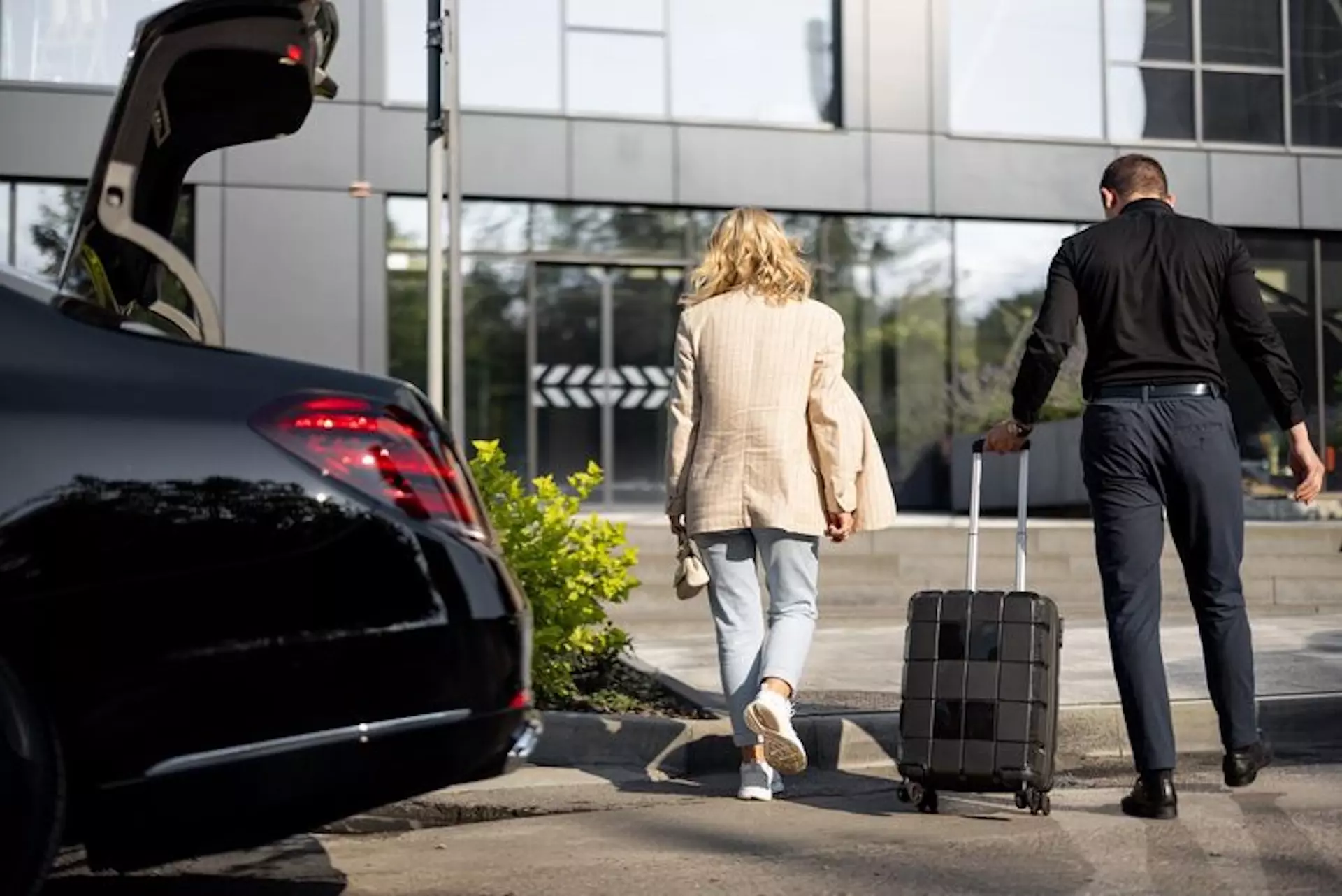 Conducteur d'un taxi aidant une femme à entrer dans l'aéroport