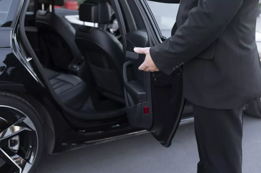 chauffeur privé qui ouvre la porte à un client qui va à Lyon