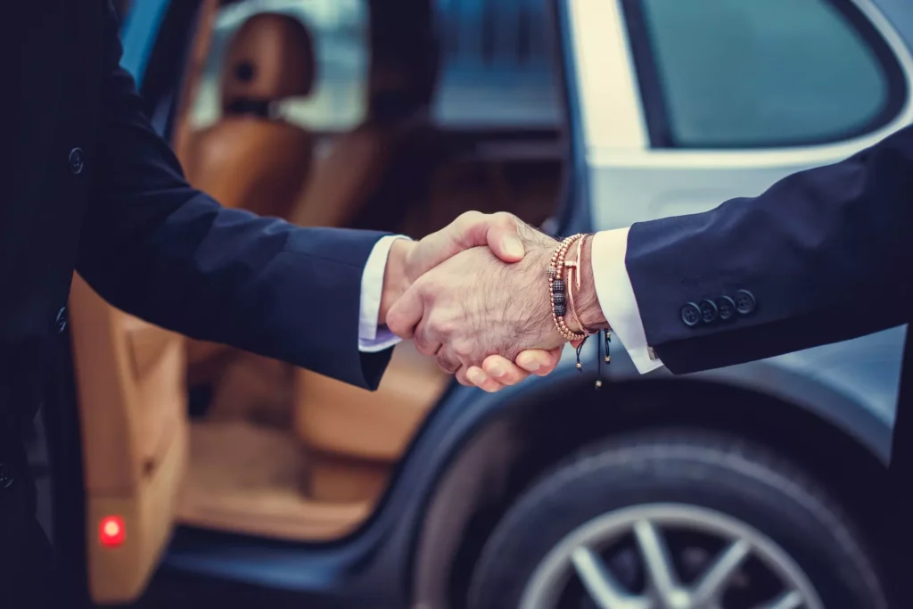 Chauffeur privé qui sert la mains à un client qui est bien arrivé àGrenoble